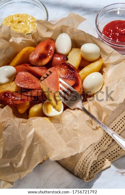 Salchipapas fritas y salchichas cortadas con huevos de ...