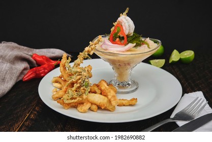 Peruvian food: called "Leche de tigre" and "chicharron", peruvian fresh fish on glass (Raw fish cocktail ceviche with lime, grinder, chili and cilantro). Selective focus