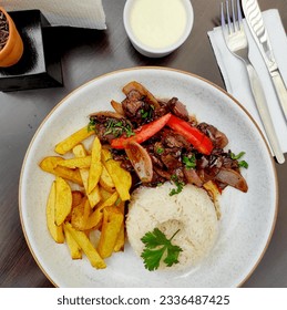 
					Peruvian food "lomo saltado": salted meat with tomatoes, onion, fried potatoes and rice.