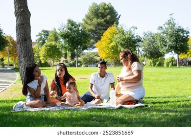 Peruvian multigenerational family having a picnic in a park outdoors - Powered by Shutterstock