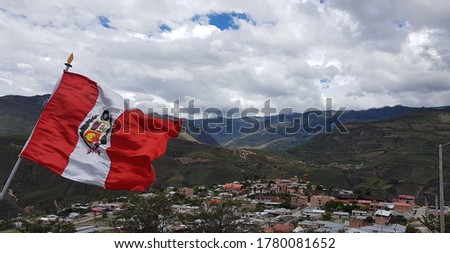 Peruvian national flag above Andes mountain village, Peru