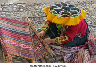 Peruvian woman - weaver in traditional dress weaving a tapestry, Peru