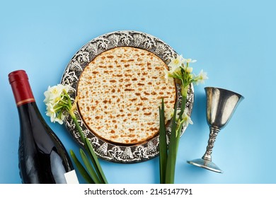 Pesah celebration concept, jewish Passover holiday. Matzah and red kosher. Traditional ritual Jewish bread on blue background