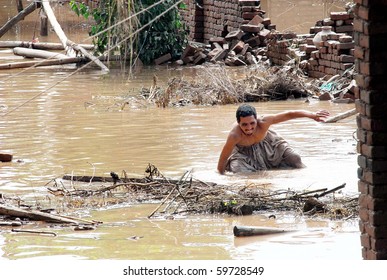 PESHAWAR, PAKISTAN - JUL 30: An unidentified man searches for his belongings in flood water at his house at Charsadda road on July 30, 2010 in Peshawar. (Fahad Pervez/PPI Photo)