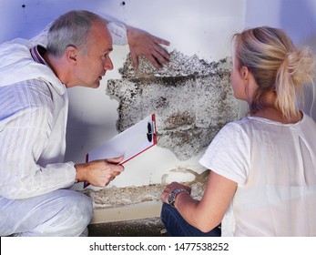 a pest control contractor or exterminator with a blonde female customer at a mold destroyed wall and explain her the problem and the plan whats to do against mold pests and bugs for hygienic