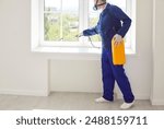 Pest control man worker, wearing protective workwear, sprays insecticide around the house, effectively eliminating insects and bugs, ensuring a clean and pest free home environment.