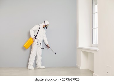 Pest control service guy visits the house. Man in white protective overalls holding yellow sprayer and spraying cockroach insecticide along wall for safe living environment inside residential building - Powered by Shutterstock