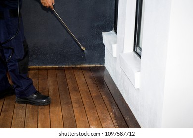 Pest Control Worker Spraying Pesticide Outside The House