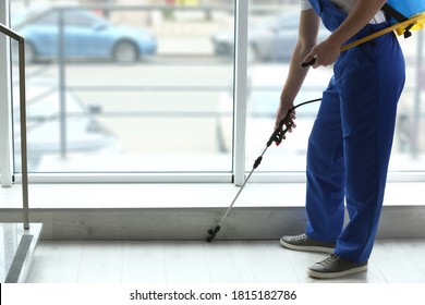Pest control worker spraying pesticide near window indoors, closeup