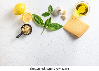 Pesto ingredients Parmesan cheese, basil leaves, pine nuts, olive oil, garlic and salt. Traditional Italian cuisine. white background with a space for a text, view from high angle - Powered by Shutterstock