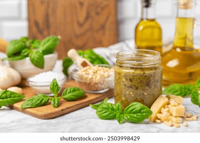 Pesto. Italian basil pesto sauce on a textured wooden background. Ingredient for pesto sauce: fresh basil, pine nuts, Parmesan cheese and olive oil. Space for text.Copy space. - Powered by Shutterstock