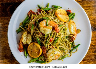 Pesto Pasta with jumbo shrimp and pesto sauce (extra virgin olive oil, pine nuts and basil), mixed with fresh chopped asparagus and halved cherry tomatoes served over homemade pasta & seasoned w/ s&p.