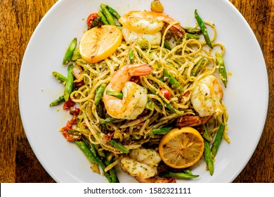 Pesto Pasta with jumbo shrimp and pesto sauce (extra virgin olive oil, pine nuts and basil), mixed with fresh chopped asparagus and halved cherry tomatoes served over homemade pasta & seasoned w/ s&p.