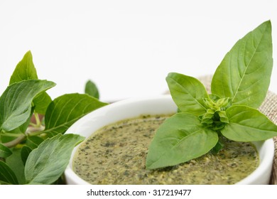 Pesto sauce and basil leaves, isolated on white background - Shutterstock ID 317219477