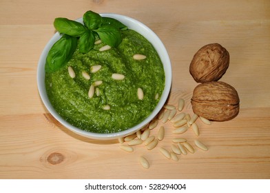pesto sauce and ingredients over wooden background