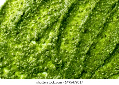 Pesto Spread Texture Background. Green Italian Homemade Spilled Sauce Made Of Ground Basil, Garlic, Pine Seeds, Olives And Pecorino Sardo Cheese Pattern Top View