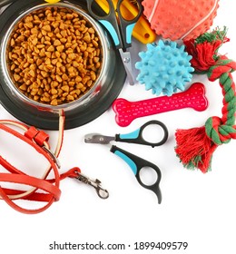 Pet accessories concept. Dry food, collars and rubber toys for pet on isolated white background.