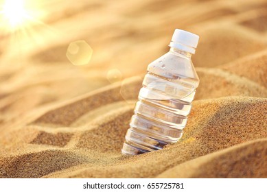 Pet Bottle With Water On The Desert.