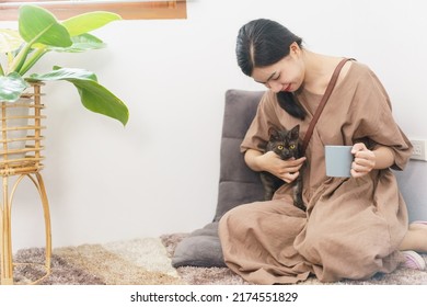 Pet Lover Concept, Young Asian Woman Relax With Drinking Coffee And Playing With Cat In Living Room.