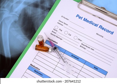 Pet Medical Record On Clipboard And Bottle Of Vaccine With Syringe.