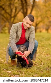 A Pet Owner Putting On The Dog-collar On His Dog