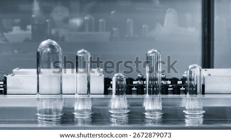 PET plastic preforms for bottle making on the conveyor belt before the hot blow molding machine