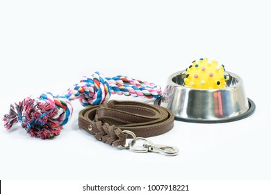 Pet supplies set about stainless bowl, rope, rubber toys and leather of leash for dog or cat on white background