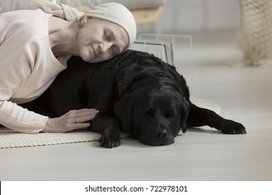 Pet Therapy Helping Sick Woman Lying With Dog On Carpet, Coping With Cancer Health Problems