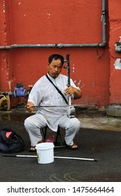 PETALING JAYA, MALAYSIA- AUG 2019: TALENTED MAN PERFORMING STREET MUSICAL ART USING TRADITIONAL MUSICAL INSTRUMENT AT ROAD SIDE IN PJ OLD TOWN, MALAYSIA 