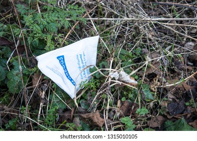 Peterlee / Great Britain - February 15, 2019: Greggs Bakery Paper Bag Thrown Away Into Park Undergrowth As Litter.  Close Up