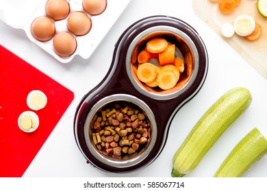 petfood set with vegetables and eggs on kitchen table background top view