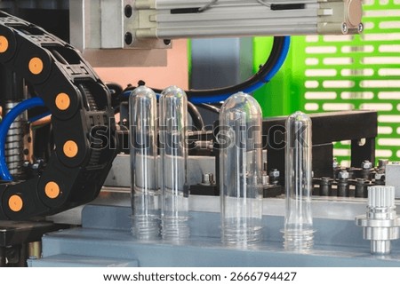 PETG plastic preforms for bottle making on the conveyor belt before the hot blow molding machine