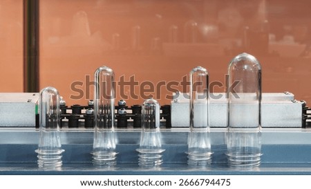 PETG plastic preforms for bottle making on the conveyor belt before the hot blow molding machine