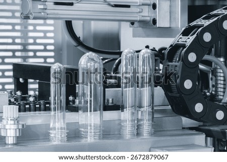 PETG plastic preforms for bottle making on the conveyor belt before the hot blow molding machine