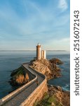 Petit Minou lighthouse and its headland, aerial view at sunset with a woman walking through the bridge