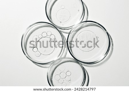 Petri dish with liquid, oil, gel, water, molecules, viruses. On a white background.