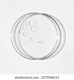 Petri dish. Petri's cup with liquid. Chemical elements, oil, cosmetics. Gel, water, molecules, viruses. Close-up. On a white background. - Powered by Shutterstock