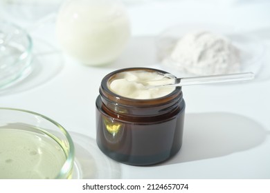 Petri Dishes With Medium And Glassware On A Laboratory Table. Fermentation, Fermented Beauty Skin Care. Container With Cream Or Solution Or Serum For Anti Age Treatment Developed In A Lab.