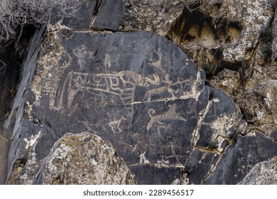 Petroglyphs wild animals. Rock paintings. Cave art pattern made of ancient hunters. Hunting scenes. Palaeolithic stones with petroglyphs. Petroglyphs carved in rocks and stones. Uzbekistan, Sarmishsay