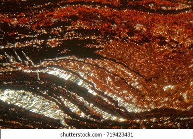 Petrographic thin section under the microscope and with polarized light. Thin sections are geological samples. The rock is an iron ore from the Banded Iron formation of Precambrian age. 