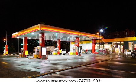Petrol gas station station at night with lights on and mini-mart 
