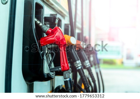 Petrol pump filling fuel nozzle in gas station. Fuel dispenser machine. Refuel fill up with petrol gasoline. Petrol industry and service. Red petrol fuel nozzle. Petroleum oil industry. Oil crisis.