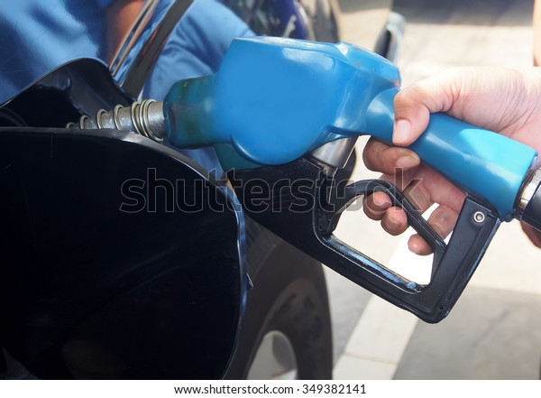 petrol pump filling at gas station hand holding\
fuel nozzle