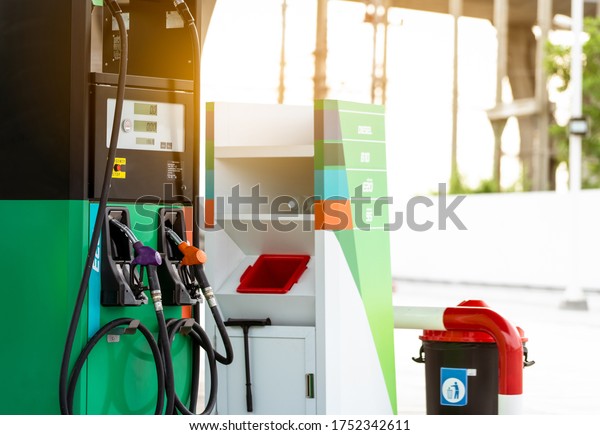 Petrol pump filling nozzle in gas station. Fuel\
dispenser machine in gas station. Petrol gasoline and gasohol.\
Petrol industry and service. Petrol price and oil crisis concept.\
Petroleum oil industry.