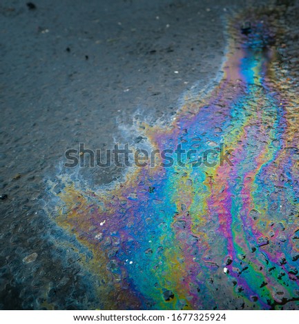 Petrol spill on tarmac. Rainbow colors from chemical spillage on the road. 