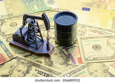 Petroleum, petrodollar and crude oil concept : Pump jack and a black barrel on US USD dollar notes, depicts the money received or earned from sales after investment in the development of oil industry. - Shutterstock ID 1066809551