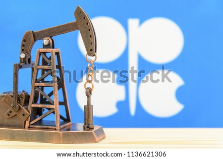 Petroleum, petrodollar and crude oil concept : Pump jack and flag of OPEC or Organization of Oil Exporting Countries, depicts the investment in the development or production of global oil industry.