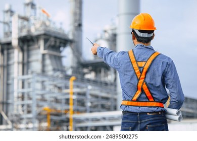 Petroleum Refinery industry engineer male working against oil and gas power industrial factory. Petrochemical power plant industry professional worker.