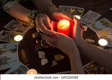 Petropavlovsk, Kazakhstan, March.15.20.Female Hands Hold A Lighted Candle In The Dark At Night. A Fortune Teller Performs A Magical. Ritual Of Enchantment And Clairvoyance. Seance And Prediction 