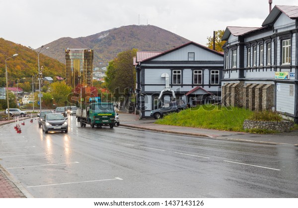 Petropavlovsk-Kamchatsky,\
Russia- 05 2014 October: Traffic on Lenin Street. Glass, yellow\
Asia Pacific Bank building and Kamchatka Center for Labor\
Protection in the\
background.